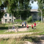 Heinjoen lapsia potkimassa palloa
